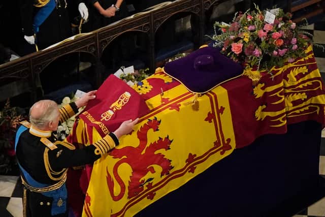 King Charles III laid the Camp Colour on Queen Elizabeth II’s coffin before it was lowered into the Royal Vault.