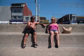 People enjoy the sunshine on the beach in Blackpool, north west England on June 14, 2023.