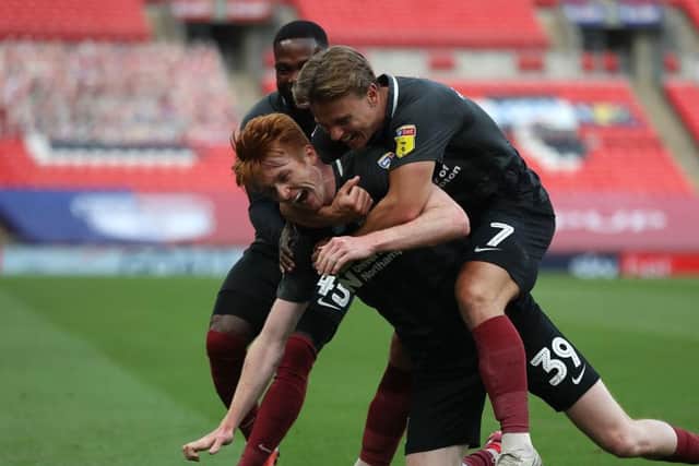 Morton is mobbed after putting Northampton 2-0 up at Wembley