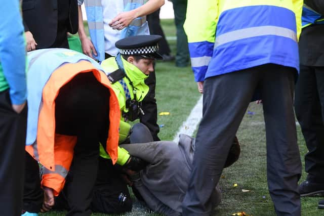 Police grapple with a fan during the Leeds-Birmingham clash