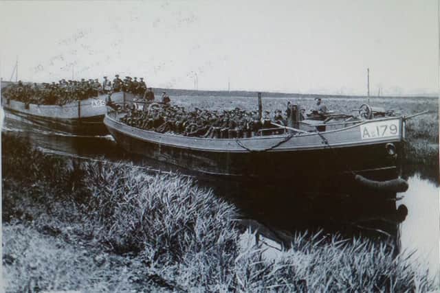 British soldiers being ferried to the front in French commandeered barges. The steerers are called-up British boatmen put into Royal Engineers uniform. Michael Ward could well have done this work. Imperial War Museum.