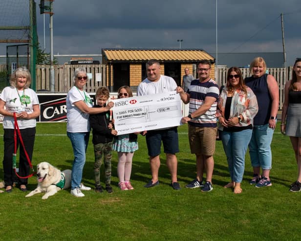 Darren and Stuart Hobbs hand over the cheque to Dogs for Good.
Picture: Richard Nunney.