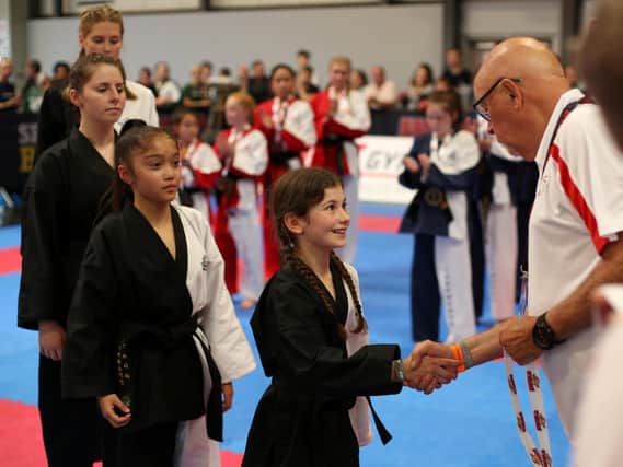 Alara Yildirim receiving her Gold Medal from Grand Master David Oliver (9th Degree Black Belt, Chairman of the British Taekwondo Council), performing a synchronised pattern with the rest of the England Girls’ Team, sparring her Welsh counterpart in the final, and the medal she won.