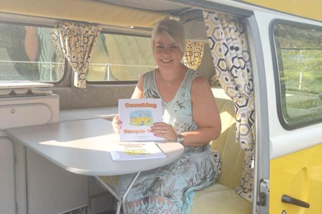 Debbie Burt with her first two books, Counting Camper Van and Daisy's story, sat in Daisy.
