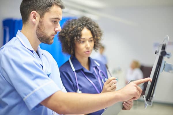 A hospital nurse and doctor review patient records