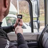 Police officers use an unmarked HGV to get an elevated position where they can see if drivers are committing offences.