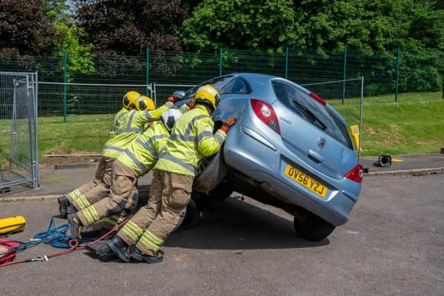 The crew attempt to put a car on its right side as they take on a drill simulating a road traffic collision