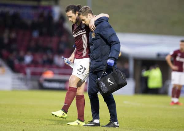 John-Joe O'Toole is helped off the pitch by physio Anders Braastad after injuring his left ankle against Scunthorpe last weekend (Picture: Kirsty Edmonds)