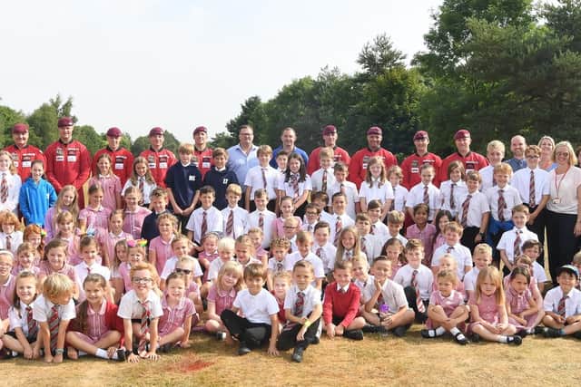 Pupils and staff from Staverton CE Primary School with Robert Wigley (chairman, The Wigley Group), James Davies (managing director, The Wigley Group) and the Red Devils.