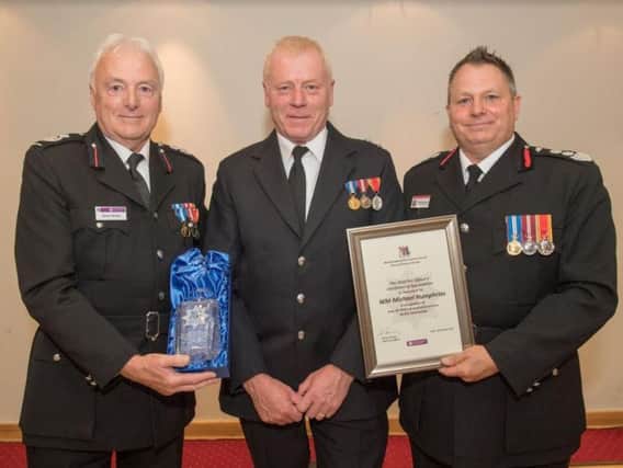 Michael Humphries (centre) pictured in October 2017 accepting an award for his 40 years of service