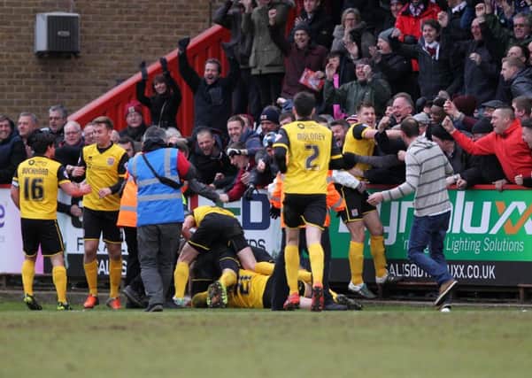 The Cobblers players and supporters celebrate Ricky Holmes' last-gasp winner at Stevenage in 2016