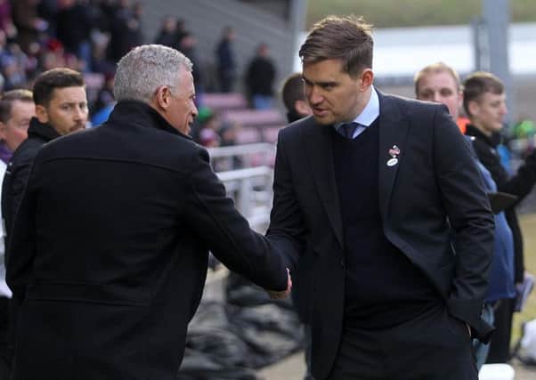 Grimsby boss Michael Jolley shakes hands with Cobblers manager Keith Curle ahead of the 2-2 draw between the sides in November