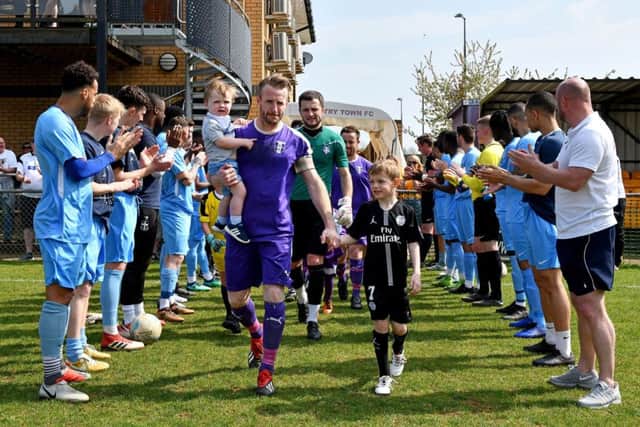 Rugby Town players and back room staff give Ross Harris and his Daventry Town team a guard of honour in Monday's derby. Photo: Martin Pulley