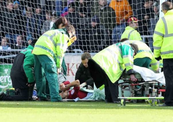 TRAUMATIC AFTERNOON - Alex Nicholls is treated on the Sixfields pitch after breaking his left leg in the game against Port Vale in October
