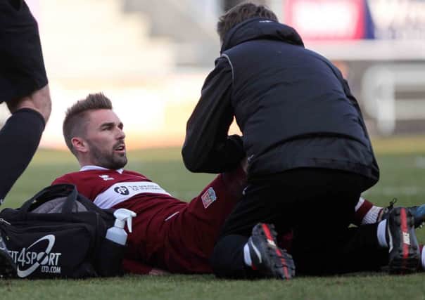BIG CONCERN - Ricky Holmes is treated after going down injured in Saturday's match against Tranmere (Picture: Sharon Lucey)