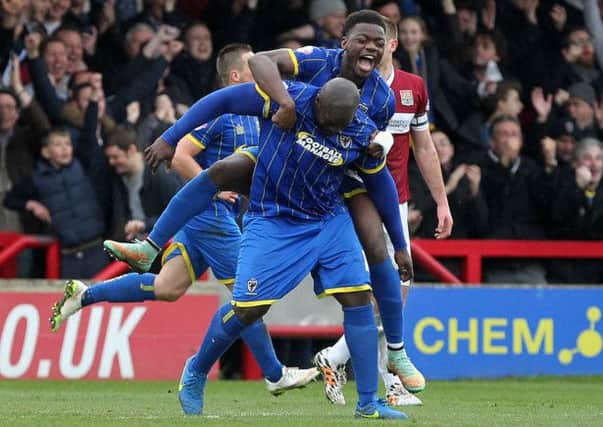 IT WAS GOING SO WELL - Adebayo Akinfnewa is congratulated after he set up Wimbledon's second goal against the Cobblers (Picture: Sharon Lucey)