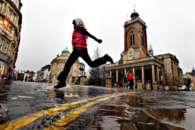 A shopper jumps over a puddle during a rainstorm in Northampton Town Centre. ENGNNL00120120301123127