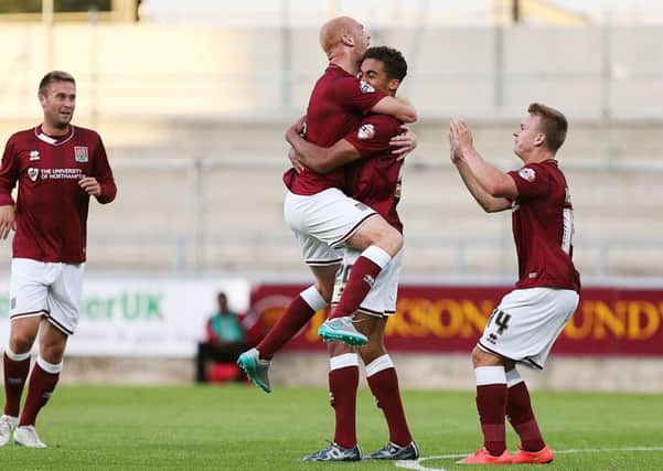 Dominic Calvert-Lewin celebrates with team-mates after netting on his Cobblers debut