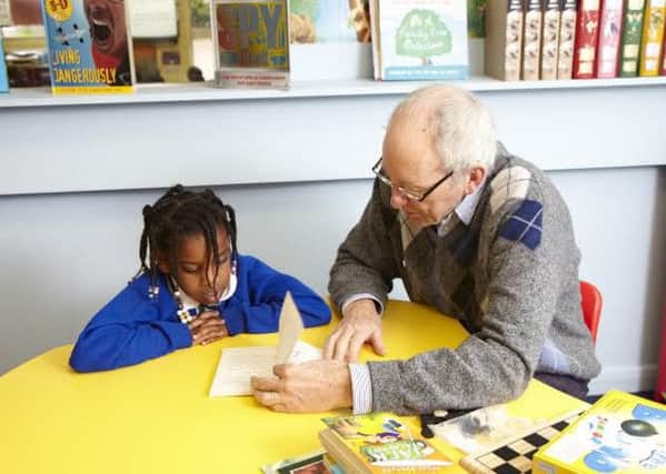 A Beanstalk volunteer helps a child with their literacy