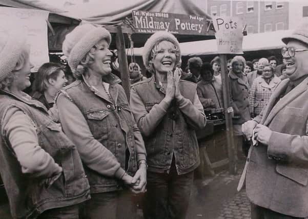 Sir Harry Secombe shares a joke with the Beverley Sisters during filming on Northampton's Market Square n 1985.