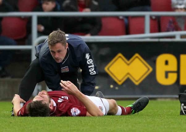 IN PAIN - Shaun Brisley receives treatment on the pitch from physio Anders Braastad after getting injured on Saturday (Pictures: Sharon Lucey)