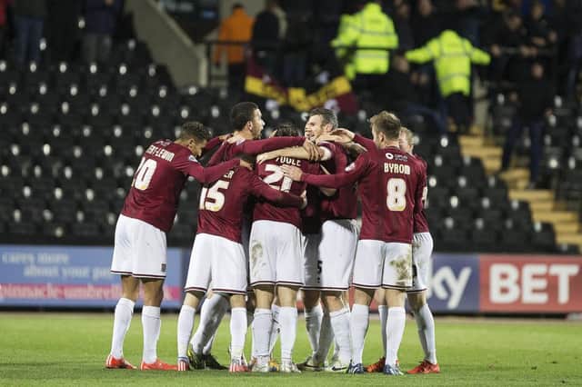 Cobblers celebrate in a huddle after Brendan Moloney's winner (pictures: Kirsty Edmonds)