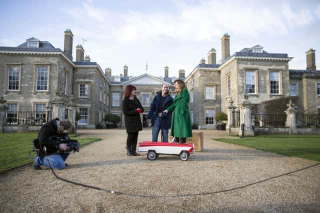 Janet Mayes and Dean Mayes showing screen expert Christina Trevanion their 1950 Tri-ang pedal car.