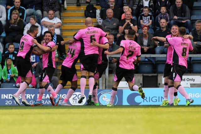 Cobblers players jump for joy after Shaun Brisley heads them into a 3-1 lead against Wycombe at Adams Park earlier this season