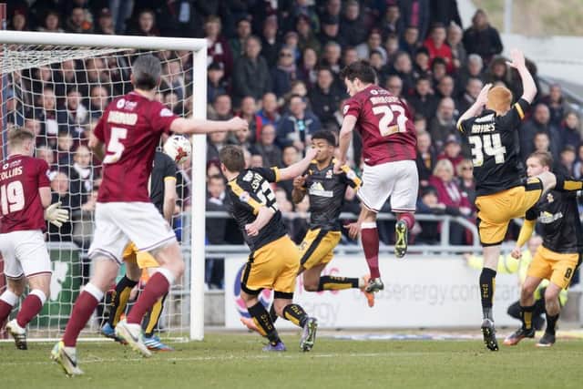 GET IN THERE - John Marquis powers home his header against Cambridge United