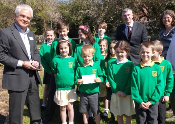 Members of the school council with headteacher John Brine (third from right) PTA chair Frances Scott-Brown (second right) and vice chair Hannah Slade (first right) accepting the cheque from Ian Southcott, Cemex community affairs manager and a trustee of the Rugby Group Benevloent Fund.