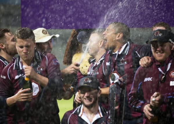 SPRAY TO WIN! - Josh Cobb (left) joins in with the Steelbacks T20 title party (Pictures: Kirsty Edmonds)