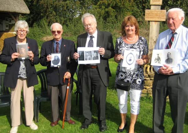 Five descendants of villagers who perished in the Great War, with the photos of their ancestors. From the left: June Ford, Arnold Baker, David Owen-Norris, Glynis Garratt and Ken Maycock.