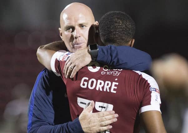 Cobblers boss Rob Page congratulates Kenj Gorre after his winning penalty in the shootout against West Brom