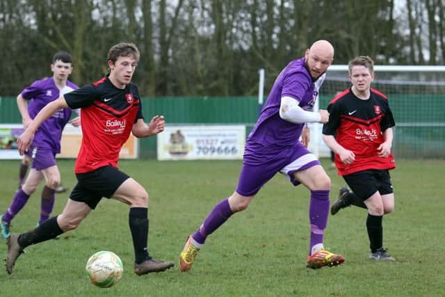 Daventry Town's Aaron King is closed down by Stewarts & Lloyds', Jack Bergin and Dylan Pearson