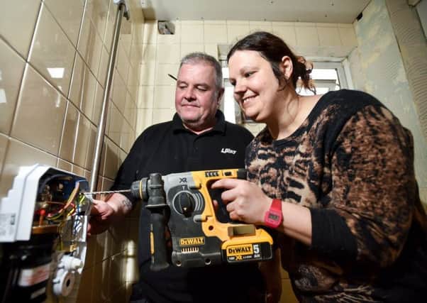 PJ Lilley plumber Dale Kimberley supervises Lisa Scraboro as she helps to install a wet room