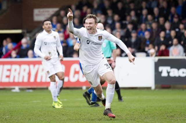 ON THE SPOT: Matty Taylor wheels away in delight after catapulting the Cobblers to three points at AFC Wimbledon. Pictures: Kirsty Edmonds