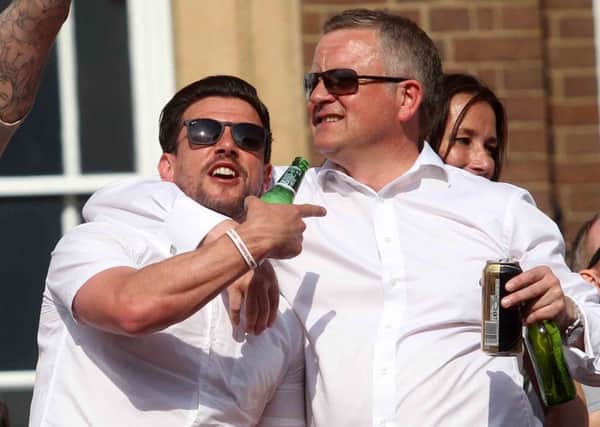 GLORY DAY - Dave Buchanan and Chris Wilder enjoy the open top bus celebrations following the Cobblers' title success last May