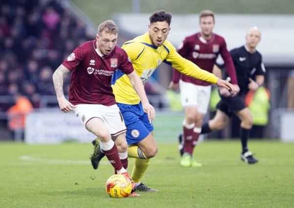 Matt Crooks tussles with Cobblers midfielder Nicky Adams while playing for Accrington at Sixfields in December, 2015