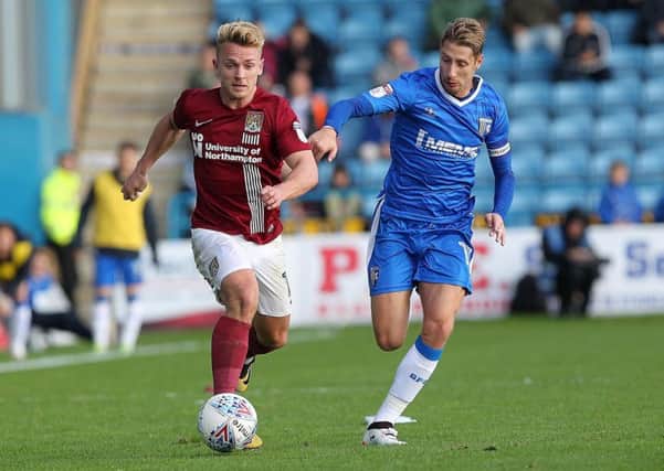 ON THE RUN - Sam Hoskins tries to get away from former Cobblers team-mate Lee Martin at Gillingham last Saturday (Picture: Sharon Lucey)
